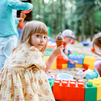 Dziewczynka trzymająca w reku babkę z piasku