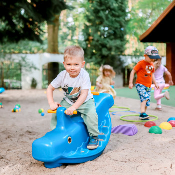 Chłopiec na bujaki na placu zabaw